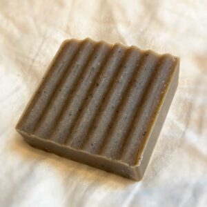 a rich brown bar of soap with dark coffee speckles and a pine tree scent